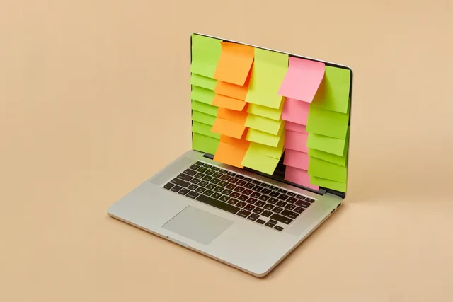A sleek laptop with a screen covered in colorful sticky notes, depicting organization and task management. Erinnerungen bei abgesagten Terminen stoppen