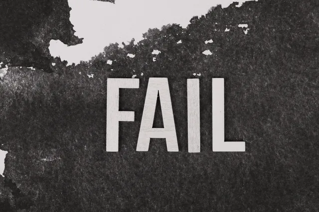 Grayscale image of the word 'FAIL' on a textured, monochrome background. Fehler in Marketing-Automationen behandeln